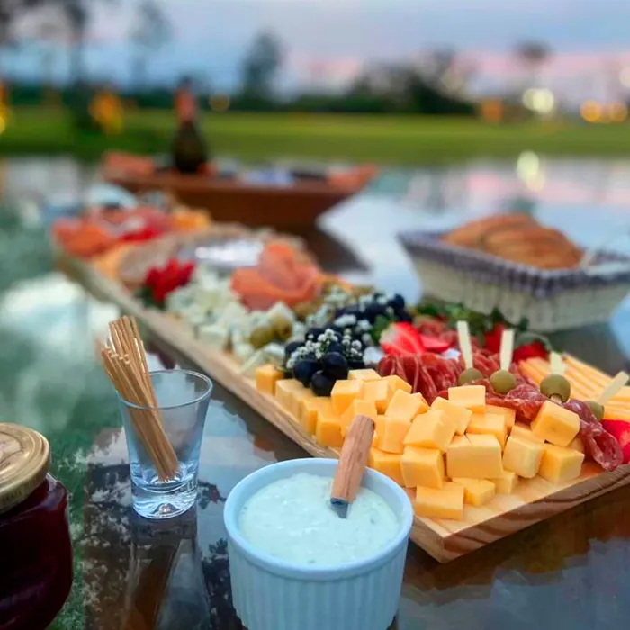 Tábua de frios ao ar livre com queijos, frutas e pasta